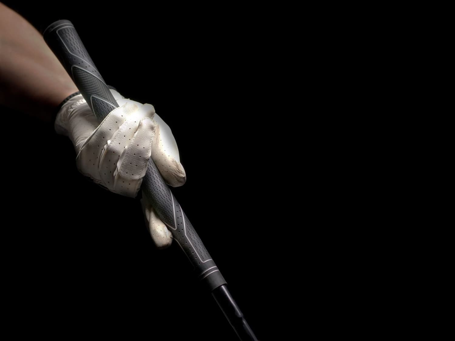 A gloved pair of hands gripping a golf club