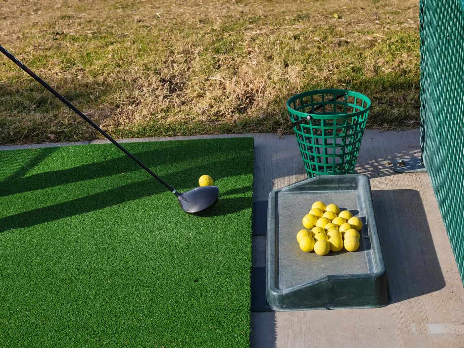 A beginner practicing a golf swing on the driving range